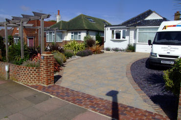 garden design Driveway of distinction and interest manmade slabs true slate contrast planted with cordyline phormiums hebes spiraes climbing roses