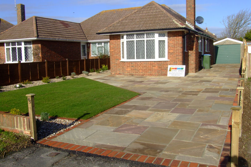 garden design Formal driveway in indian sandstone brick edging and simple evergreen planting around the edges all for low mantenance